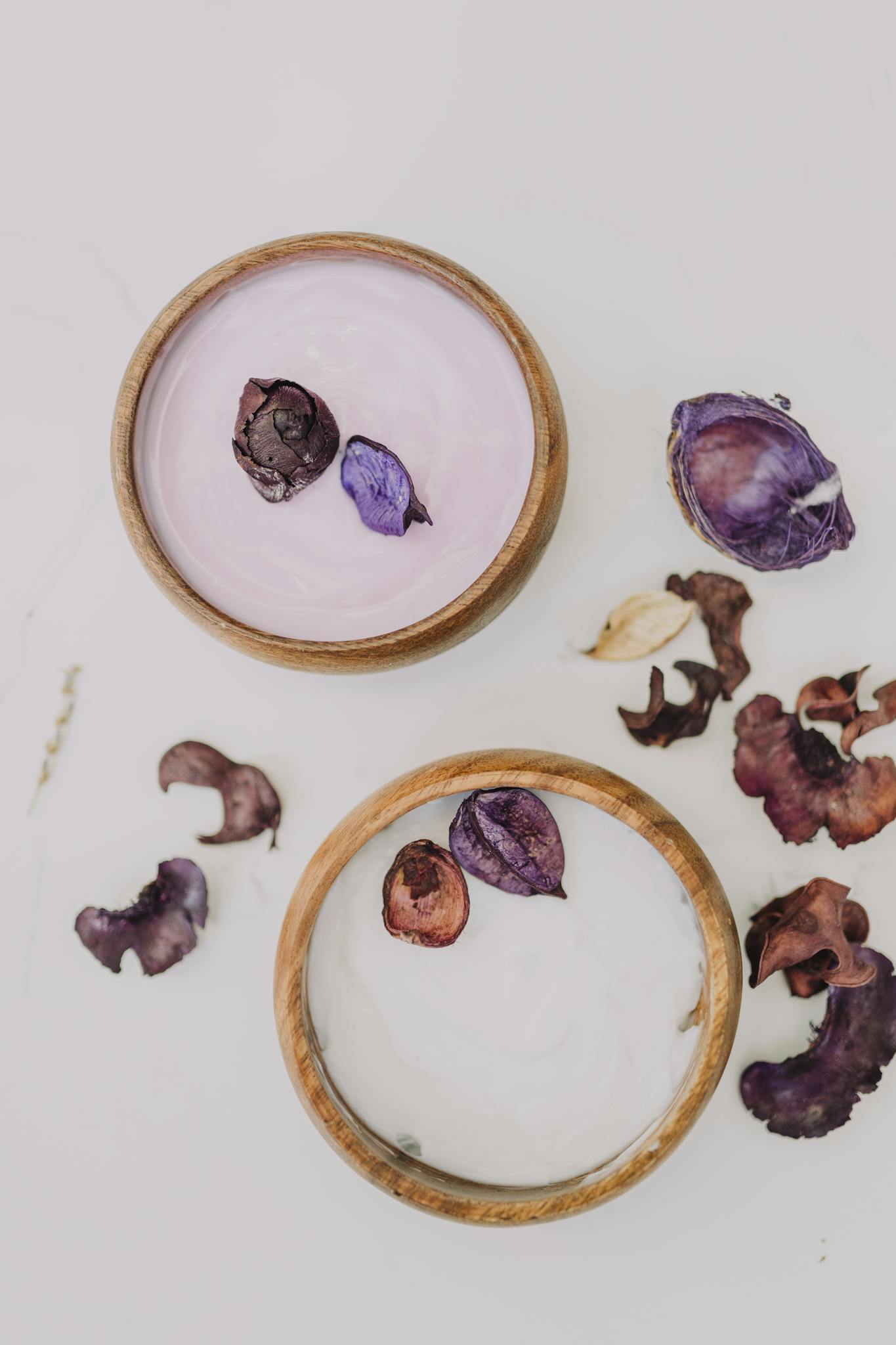 Top view of spa bowls with dried flowers for a serene self-care setup.